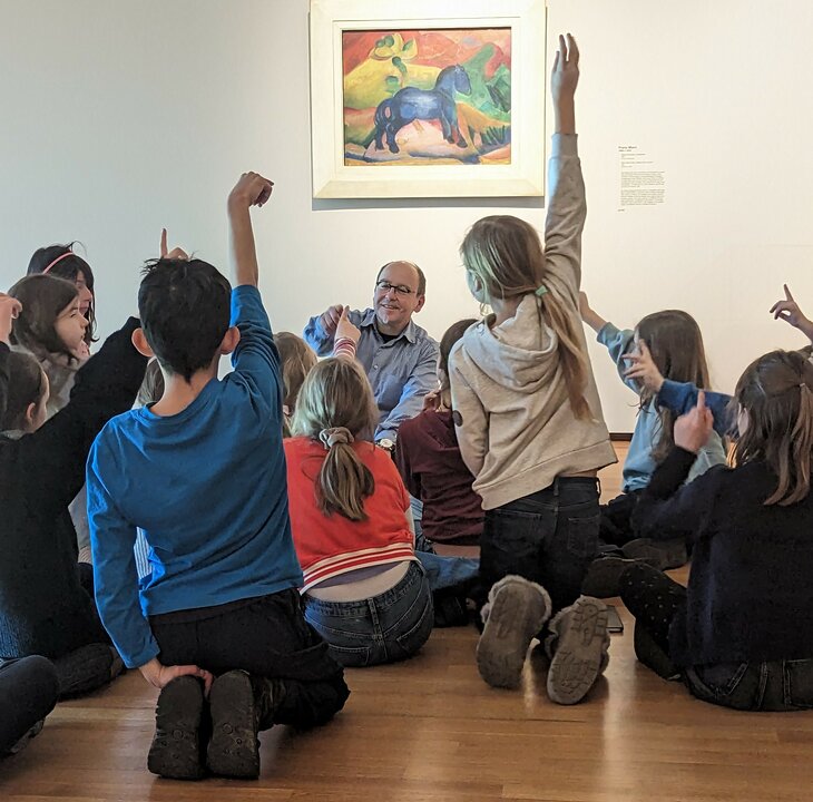 Lehrer befragt Kinder zu Kunstwerk blauem Pferd
